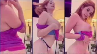 Chica de piel clara bailando mientras se quita la ropa