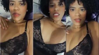 La influencer brasileña Nega Barbie luciendo un top negro transparente y alisándose las tetas