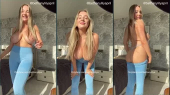 Bethanylilyapril, una rubia, se quita la ropa hasta quedarse solo con una tanga, revelando sus hermosos y voluminosos pechos
